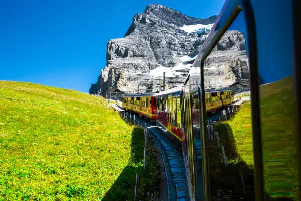Beautiful scenery with cogwheel red train of the famous Jungfrau Railway from Jungfraujoch ( Top of Europe) to Kleine Scheidegg, Bernese Oberland, Switzerland