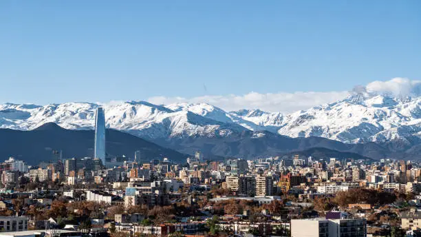 Elevated view of Providencia commune and Sanhattan (Santiago Financial District) with the snowy Andes as background at winter in Santiago de Chile