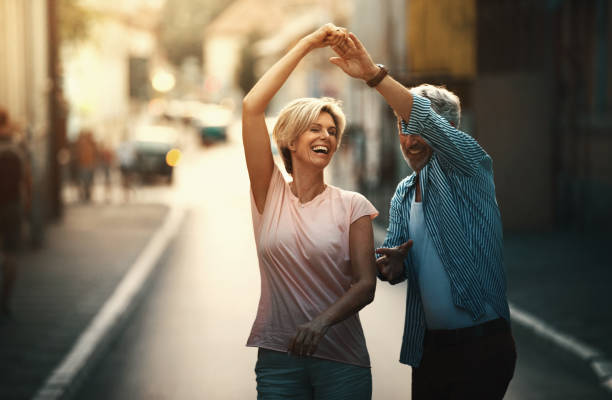 middle aged couple walking in a city street. - mid aged woman imagens e fotografias de stock