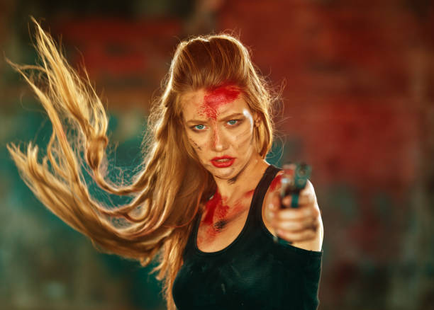 istock Sensual blond warrior pointing gun at you 1255069218