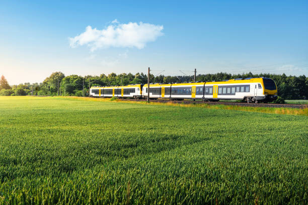German passenger train in motion. Yellow electric train traveling Electric passenger train traveling through agricultural fields, at sunrise, in Schwabisch Hall, Germany. Eco-friendly German yellow commuter train. electric train photos stock pictures, royalty-free photos & images