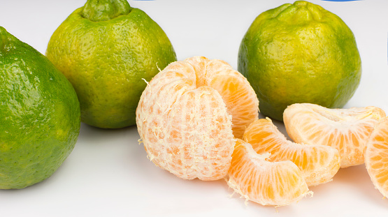 Tangerine variety typical in brazil called ponkan with one peeled isolated in white background