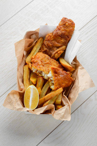 istock Fish and chips with lemon in greaseproof paper 1255076330