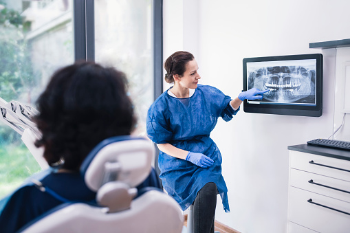 Dentista explicando radiografías dentales a un paciente. photo