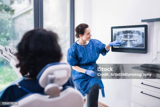 Dentist Explaining Tooth Xrays To A Patient Stock Photo - Download Image Now - Dentist, Dental Health, Dental Equipment