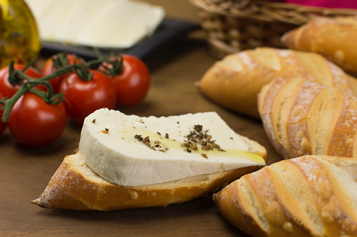 Slice of buffalo fresh cheese made in Serra da Canastra, in Italian bread in wood background