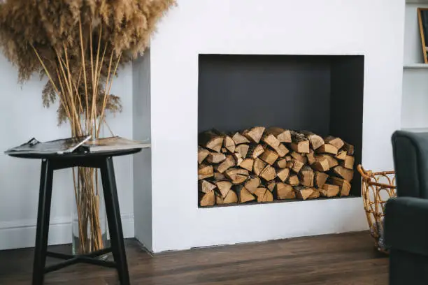 Firewood for a fireplace on a shelf in the living room interior. High quality photo