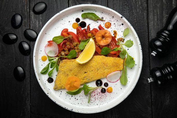 панированная филе морской рыбы. с овощным гарниром - sea bass prepared fish food grilled стоковые фото и изображения
