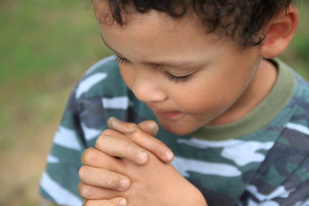 istock little boy praying stock photo 1255084967