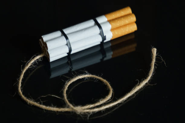 istock Cigarettes are twisted into a dynamite checker with a filament on a black reflective surface. 1255092730