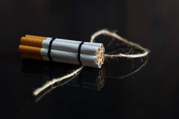istock Cigarettes are twisted into a dynamite checker with a filament on a black reflective surface. 1255092867