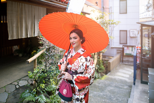 Caucasian woman in kimono walking in traditional Japanese street
