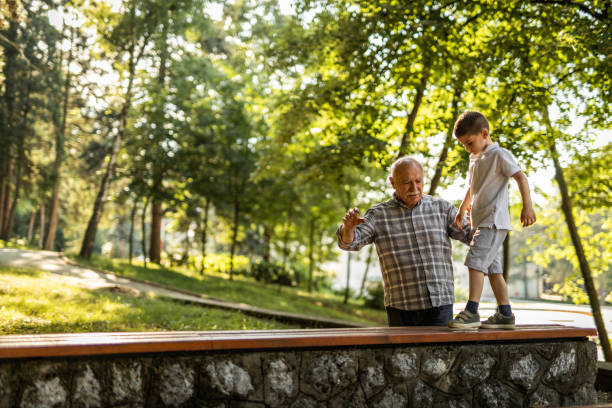 istock Grandfather helping to his grandson with balancing on bench 1255093375