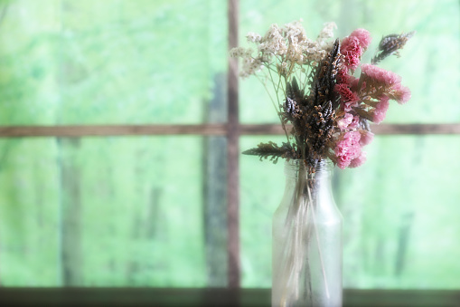 Pictured dried flowers in a glass bottle.