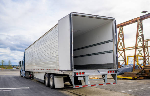 다음 배달을 기다리는 산업 지역의 창고 주차장에 열린 도어 세미 트레일러가있는 큰 장비 파란색 세미 트럭 - vehicle trailer 뉴스 사진 이미지