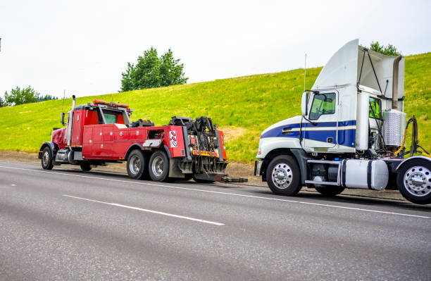 red big rig semi towing truck prepare to totow broken white big rig semi tractor standing out of service on the road side - towing tow truck truck semi truck stock-fotos und bilder