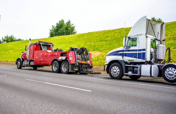 Red big rig semi towing truck prepare to tow broken white big rig semi tractor standing out of service on the road side Powerful heavy-duty big rig mobile tow semi truck with emergency lights and towing equipment prepare to tow broken white big rig semi tractor standing out of service on the road side"n towing photos stock pictures, royalty-free photos & images