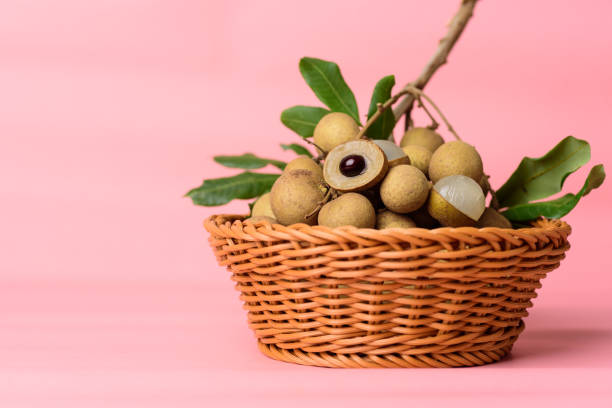 Longan fruit Fresh longan fruit in a basket on pink background, Tropical fruit longan stock pictures, royalty-free photos & images