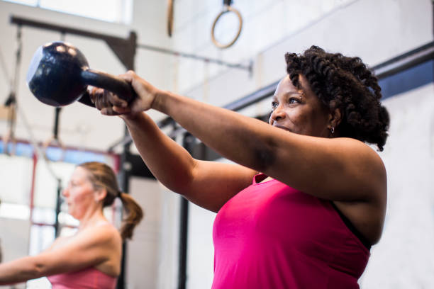 sportler trainieren mit kettlebell in der turnhalle. - kugelhantel stock-fotos und bilder