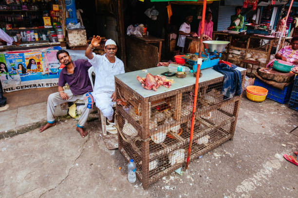 Mumbai, India - August 5 2017: A chicken meat seller at a market stall in Colaba Causeway Market in Mumbai, India