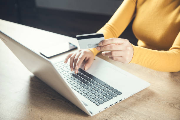 istock woman hand credit card and computer 1255109372