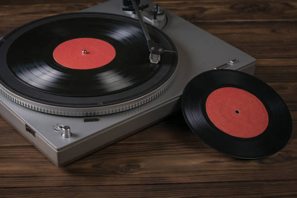 istock Two red vinyl discs and a vinyl record player on the table. 1255119056