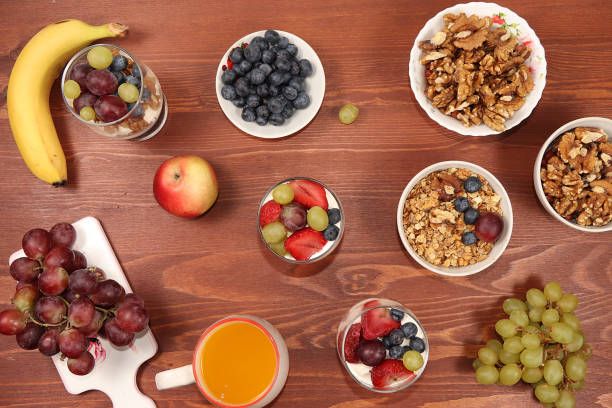 istock Useful breakfast with ingredients, flat lay, fruit salad with granola, grapes, bananas, strawberries and apple on a wooden table. The concept of losing weight, detox diet, lifestyle, 1255121933