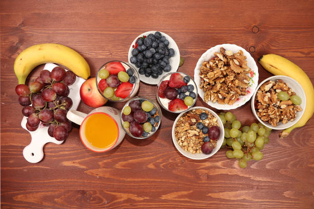 istock Useful breakfast with ingredients, flat lay, fruit salad with granola, grapes, bananas, strawberries and apple on a wooden table. The concept of losing weight, detox diet, lifestyle, 1255121934