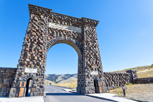 Low angle view of the historic Roosevelt Arch at the north entrance of Yellowstone National Park in Gardiner, Montana.