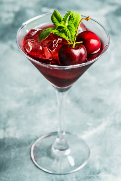 istock Cherry cocktail in martini glass with berries and mint leaves 1255126785