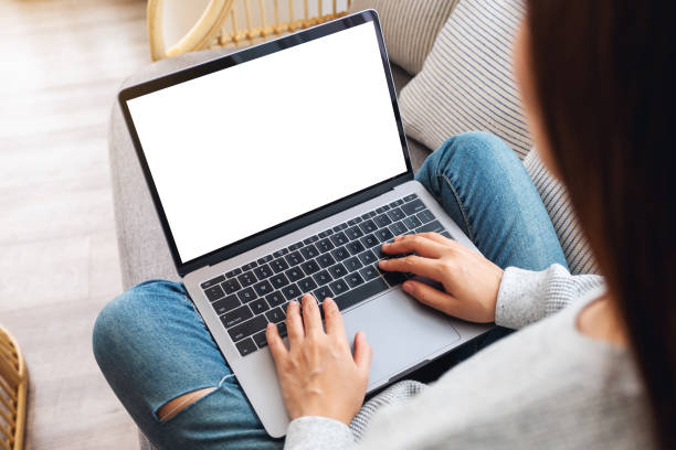 istock a woman working and typing on laptop computer with blank screen while sitting on a sofa at home 1255126796