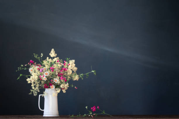 wild flowers in white jug on dark background