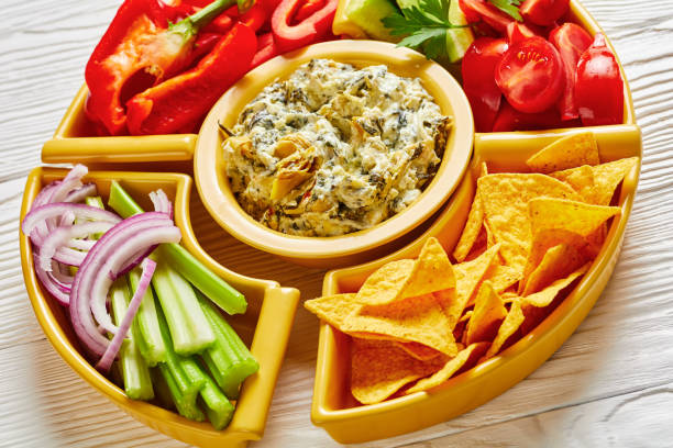 istock Spinach Artichoke cheese Dip set with Tortilla Chips, cucumber, celery sticks, tomato slices and red bell pepper, 1255132066
