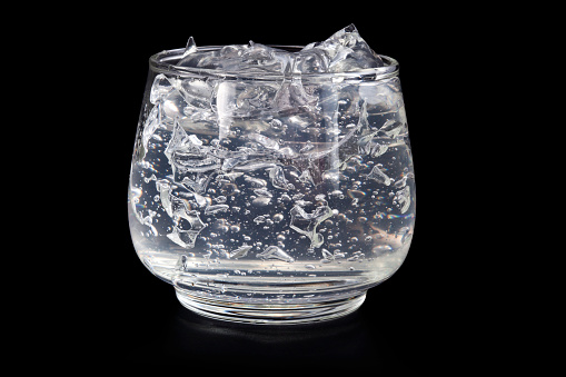 Bubble gel in a glass jar isolated on a black background.