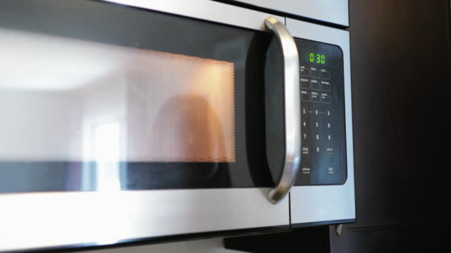 asian young woman using microwave