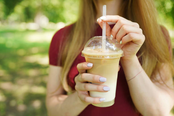 istock Close up of takeaway cold coffee in womans hands 1255137146