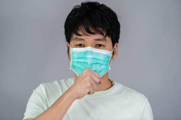 istock sick man wearing surgical mask (medical mask) is coughing 1255140580