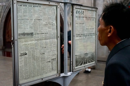 A passenger of the Korean metro reads the newspaper on the billboards placed at the stations.
