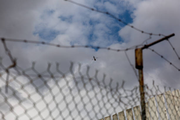 istock Helicopter flying over a barbed wire fence 1255142045