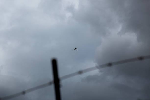 istock Helicopter flying over a barbed wire fence 1255142068