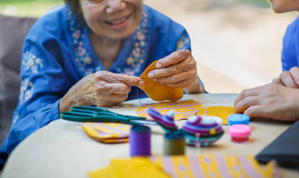 idosa com cuidadora na agulha faz terapia ocupacional para alzheimer ou demência - japanese ethnicity women asian and indian ethnicities smiling - fotografias e filmes do acervo