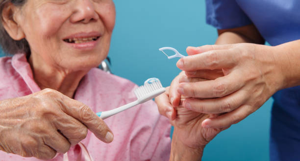 caregiver take care asian elderly woman while using dental fross stick. - dental hygiene dental equipment brushing teeth dental floss imagens e fotografias de stock