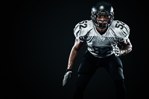 American Football player on stadium with smoke and lights.