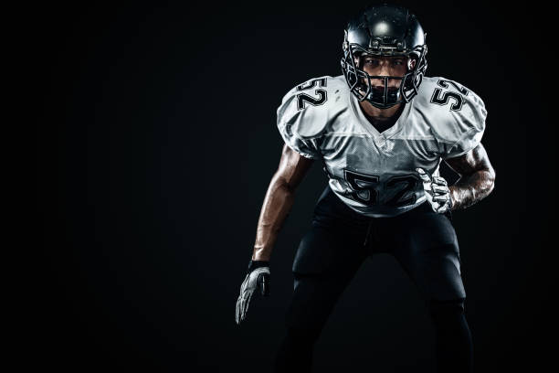 American football sportsman player in helmet on black background. Sport and motivation. Team sports. stock photo