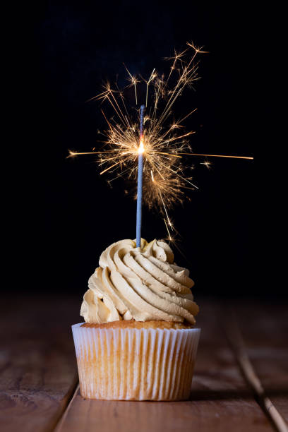 istock One cupcakes on a table with a sparkle and a black background 1255150713
