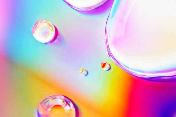 istock Abstract composition. Drops of liquid are on an iridescent surface. Slightly defocused image. Trending background of saturated colors and gradients. 1255150726