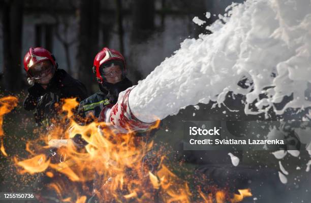 Firefighters Extinguish A Fire Lifeguards With Fire Hoses In Smoke And Fire Stock Photo - Download Image Now