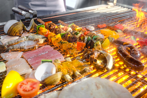 A close-up photo of barbecue food being grilled on top of a charcoal grill for barbecue party