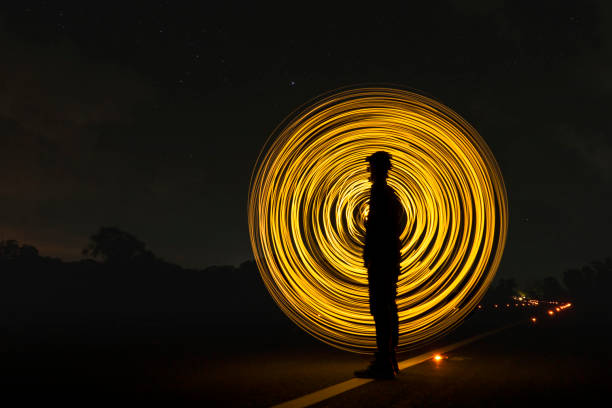 istock Silhouette men with light circle background in the night on the road. 1255150861
