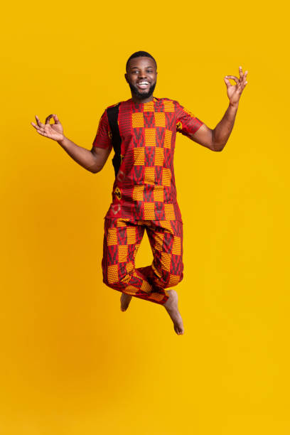 istock Carefree african guy jumping up over yellow studio background 1255153221